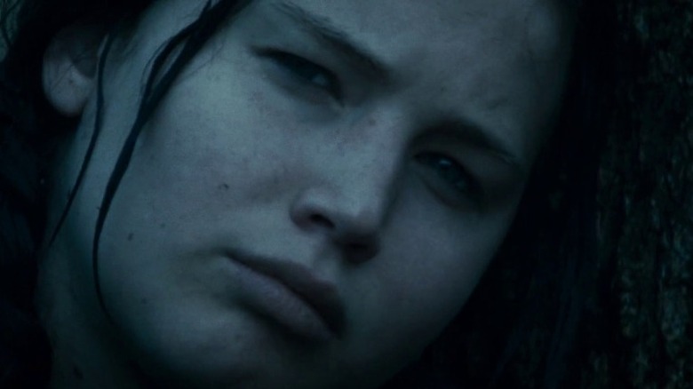 Katniss Everdeen leans her head against a tree trunk