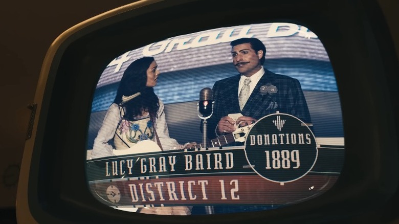 Lucy Gray Baird and Lucky Flickerman appearing on a TV screen