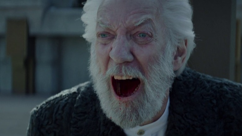 Coriolanus Snow laughs maniacally with a blood-filled mouth