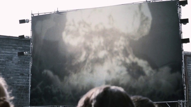 A large screen at a public square showcasing a bomb explosion