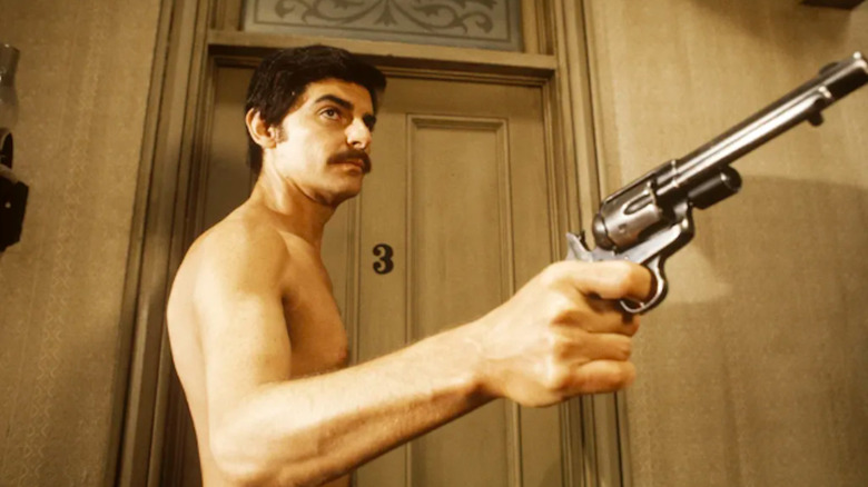 A shirtless Richard Benjamin brandishes a pistol as Peter Martin in Westworld