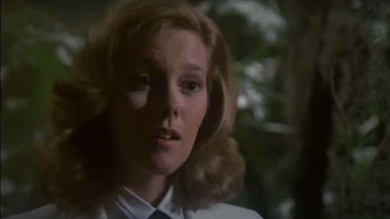 Wendy Scaal's Julie wears a white shirt and black bowtie and stands in some greenery on Fantasy Island