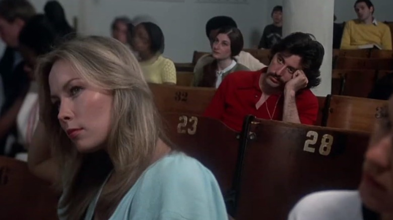 Al Pacino's Frank sitting behind Cornelia Sharpe's Leslie in a crowded lecture hall in Serpico