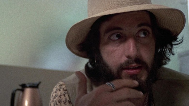 Al Pacino's Frank, hand on face, wearing a hat, in Serpico