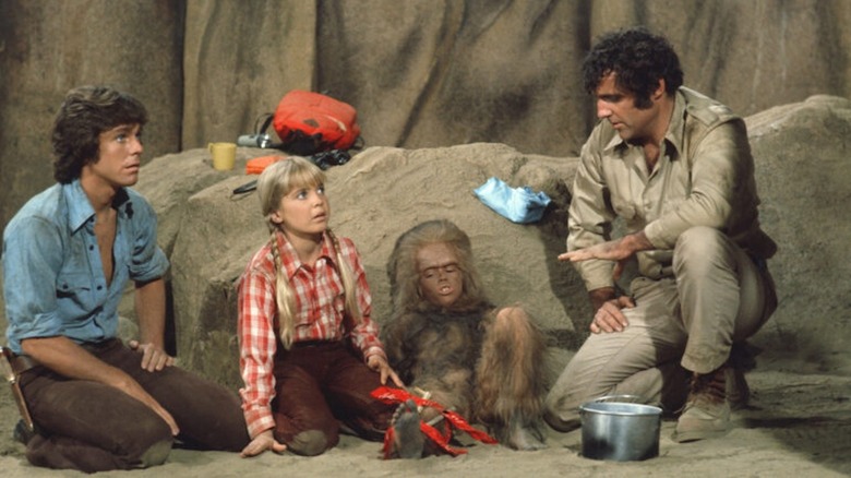 Wesley Eure as Will Marshall, Kathy Coleman as Holly Marshall, Spencer Milligan as Rick Marshall, and Phillip Paley as Cha-Ka hide out in a cave in Land of the Lost