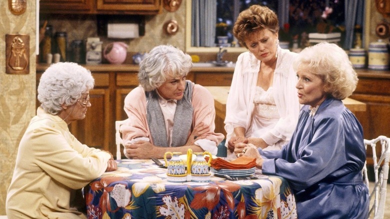 Estelle Getty as Sophia Petrillo, Bea Arthur as Dorothy Zbornak, Rue McClanahan as Blanche Devereaux and Betty White as Rose Nyland sit at the kitchen table in The Golden Girls