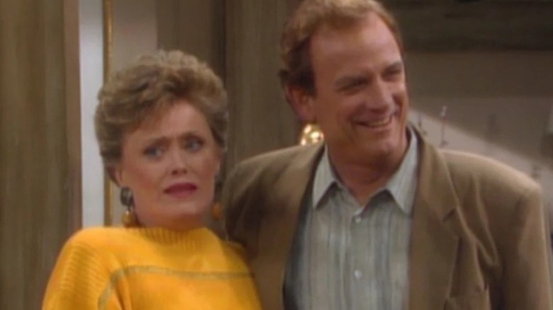 A grinning Monte Markham as Clayton Hollingsworth hugs a confused Rue McClanahan as Blanche Devereaux in The Golden Girls