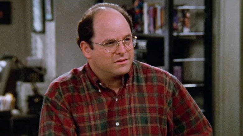 Jason Alexander's George Costanza wearing plaid, standing in Jerry's apartment in Seinfeld