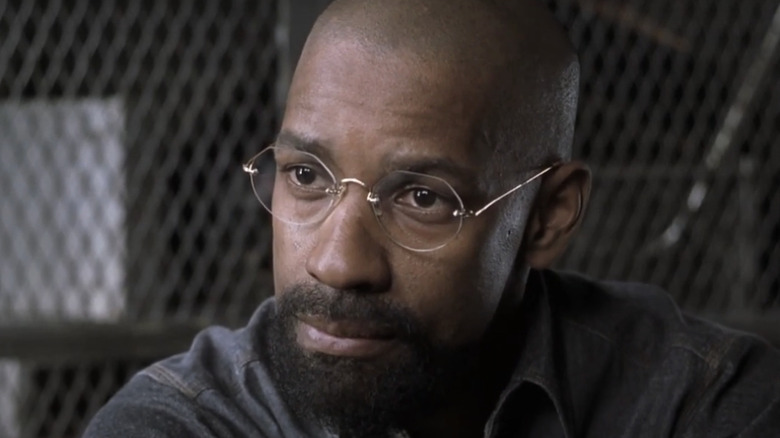 Denzel Washington's Rubin 'The Hurricane' Carter looks across the frame while wearing glasses in The Hurricane