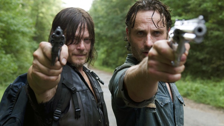 Daryl and Rick pointing guns