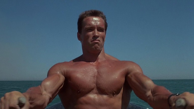 Arnold Schwarzenegger rowing a boat in Commando