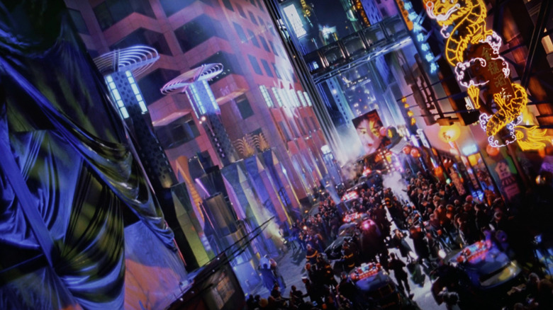 A Gotham street packed with crowds is illuminated by neon lights in Batman Forever