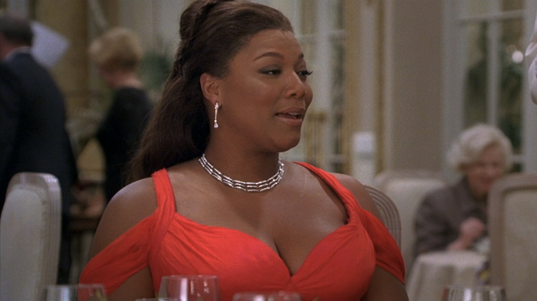 Queen Latifah's Georgia sits at a dinner table in a red dress in Last Holiday