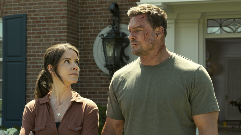 A beaten and bruised Reacher looking down at a woman standing next to him