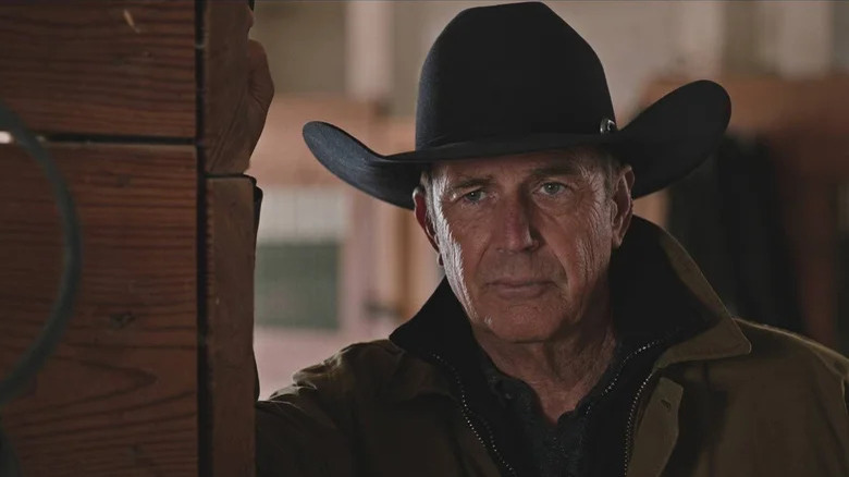 John Dutton leans against a door frame on Yellowstone