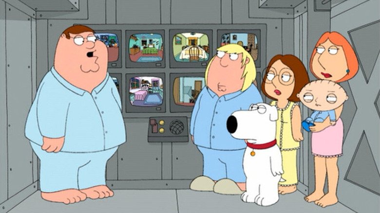 Os Griffins, usando pijama, olhando para monitores de vídeo em sua sala de pânico. Um episódio de Family Guy.