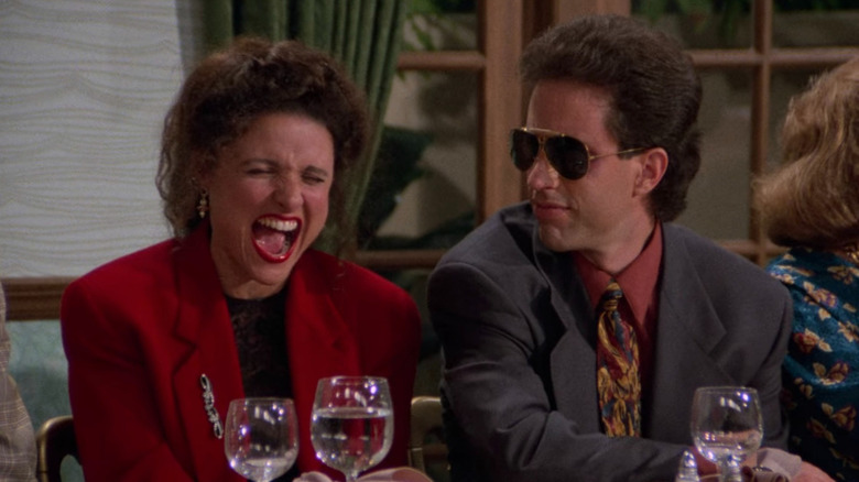 Julia Louis-Dreyfus' Elaine laughing and Jerry Seinfeld's Jerry wearing sunglasses on Seinfeld