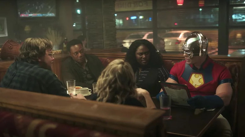 John Economos, Murn, Leota Adebayo, and Peacemaker sit at a booth in a restaurant in Peacemaker