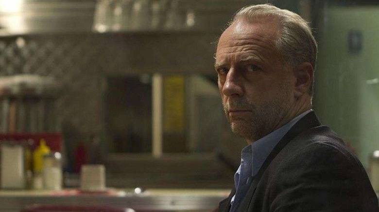 Xander Berkeley sitting in The Booth at the End