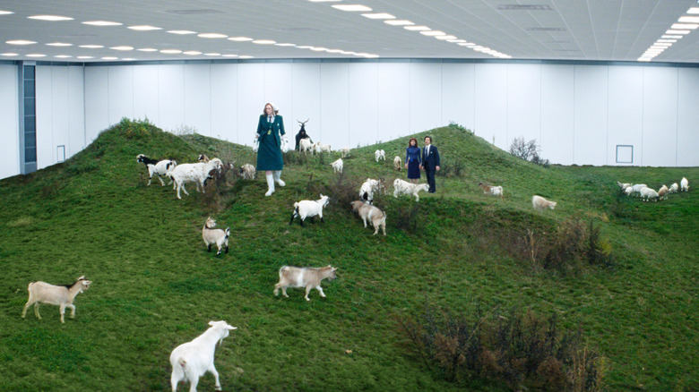 Gwendoline Christie as Lorne, Britt Lower as Helly R., and Adam Scott as Mark S. walking among a flock of goats in Severance