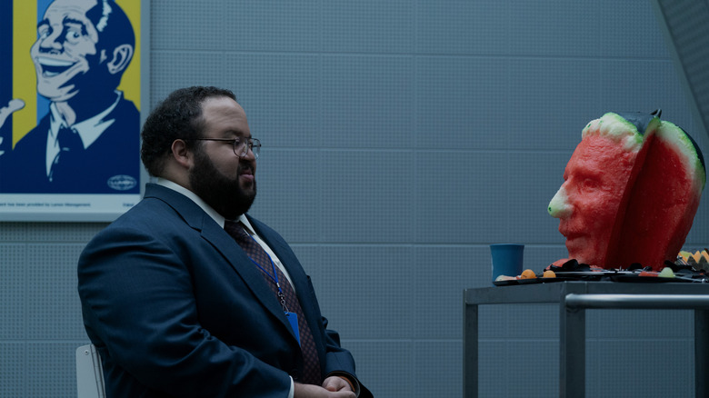 Zach Cherry as Dylan G. staring mournfully at a watermelon recreation of John Turturro's Irving B. in Severance