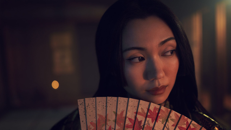 Lady Ochiba holds a fan and looks at something off-camera in Shōgun