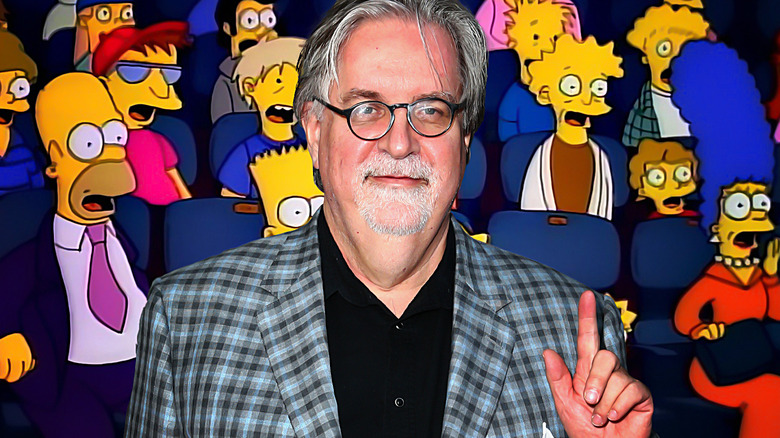 Matt Groening in front of The Simpsons sitting in a movie theater