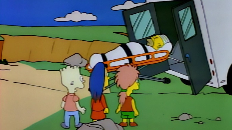 Homer Simpson, atado a una camilla, sale rodando de la parte trasera de la ambulancia en Los Simpson.