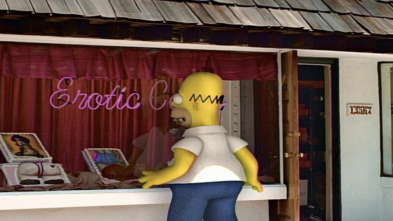 A 3D model of Homer Simpson is shown looking in a store window with an erotic cakes sign