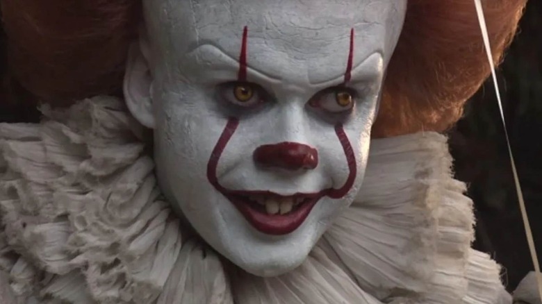 Bill Skarsgard's Pennywise smiling in clown makeup