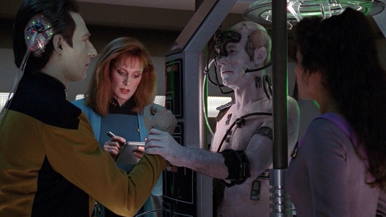 Data, Troi, dan Dr. Crusher cenderung ke kapten Borg Picard di Star Trek: The Next Generation.