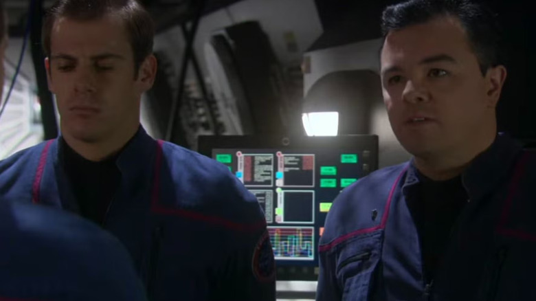 Ensign Rivers and a fellow officer looking a little defeated in front of a computer panel.