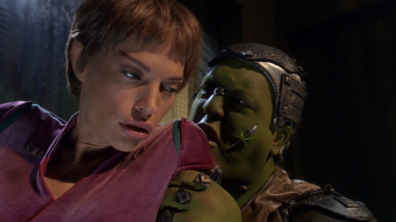 T'Pol, looking woozy, being threatened by a green-skinned Orion trader on Star Trek: Enterprise.