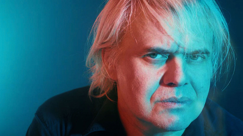 A portrait of artist H.R. Giger in front of a blue backdrop