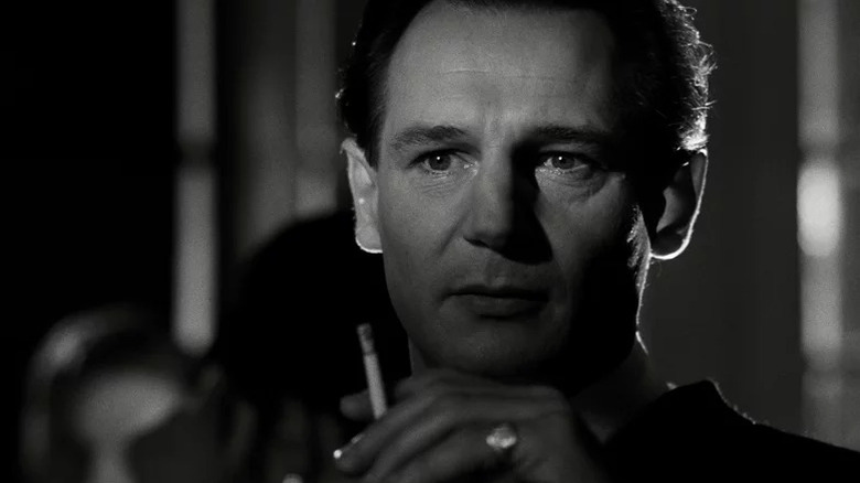 Liam Neeson's Oskar Schindler holds a cigarette in Schindler's List