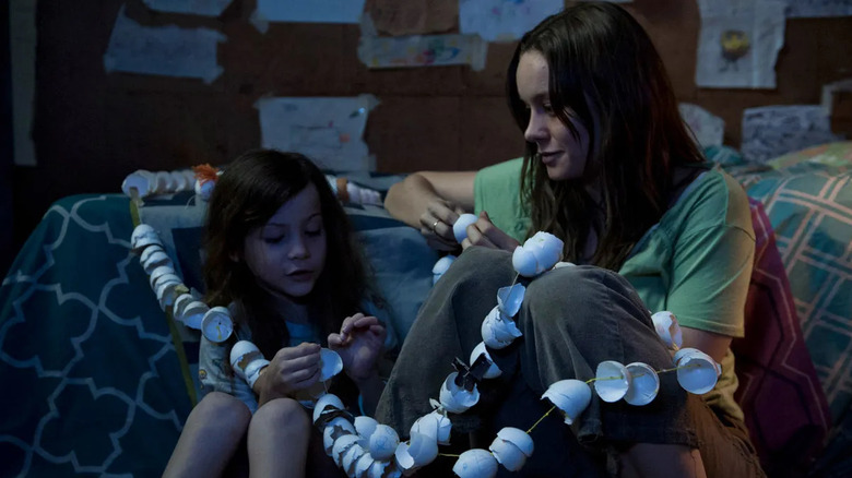 Jack and Joy playing with eggshell garlands in Room