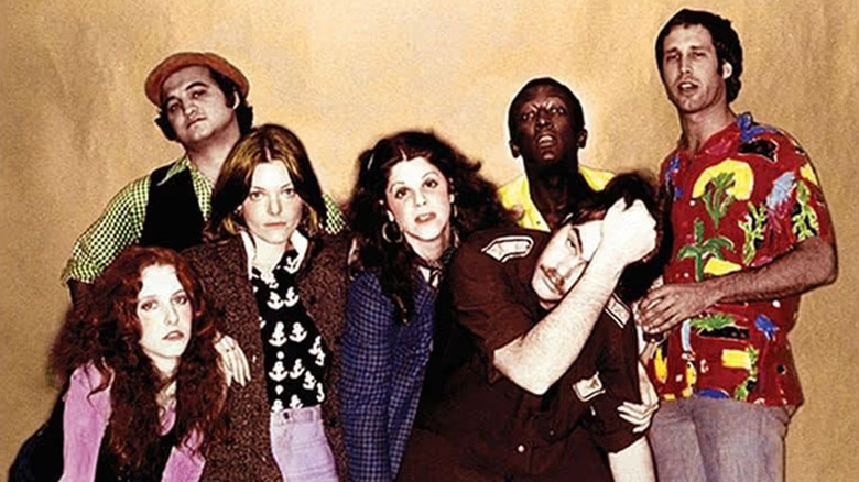 Saturday Night Live Season 1 cast photo of Laraine Newman, John Belushi, Jane Curtin, Gilda Radner, Dan Aykroyd, Graham Morris, and Chevy Chase from DVD cover