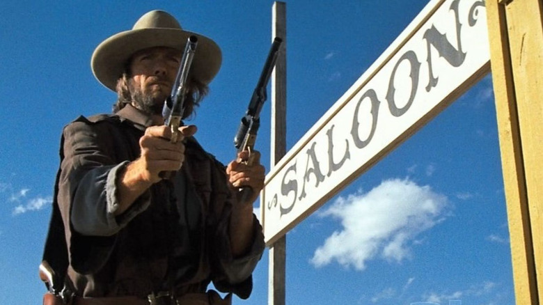 Outlaw Josey Wales holding two pistols ready to shoot