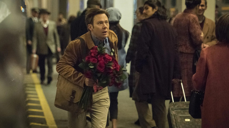 Phil (Jimmi Simpson) runs through a train station with a bouquet in The Twilight Zone (2019)