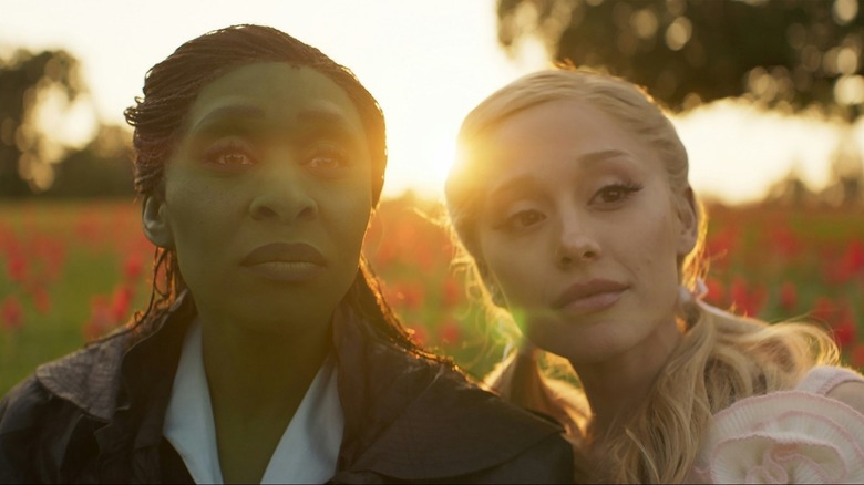 Elphaba and Galinda sitting in a giant flowerbed in Wicked