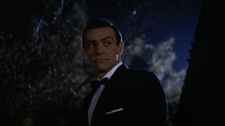 Sean Connery's James Bond stands in the night wearing a tuxedo in From Russia With Love