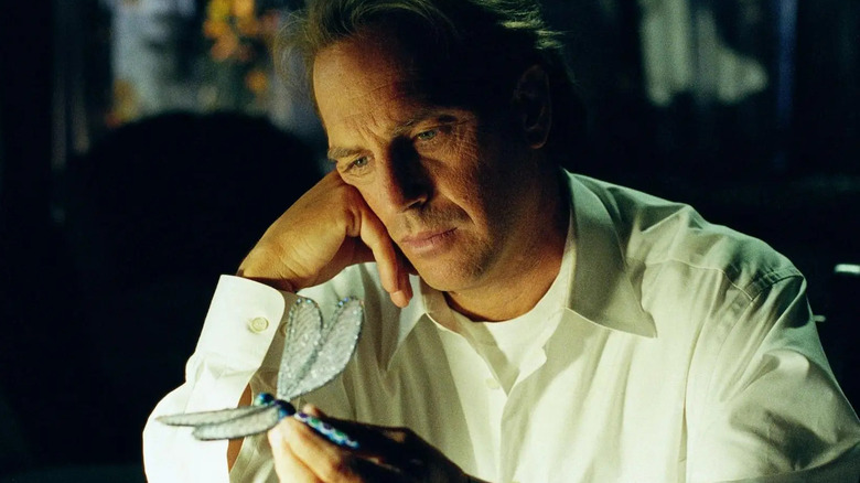 Kevin Costner como Dr. Joe Darrow, contemplando uma libélula, em Dragonfly