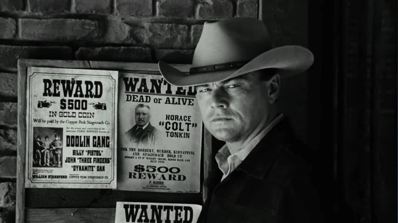 Rick Dalton's Bounty Law character standing next to wanted posters