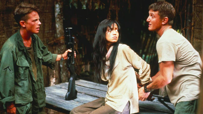 Michael J. Fox as Eriksson confronts Sean Penn as Meserve who's restraning Thuy Thu Le as Oanh in Casualties of War