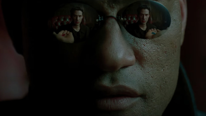 The Matrix Morpheus hlding blue pill and red pill reflected in glasses as Neo looks on