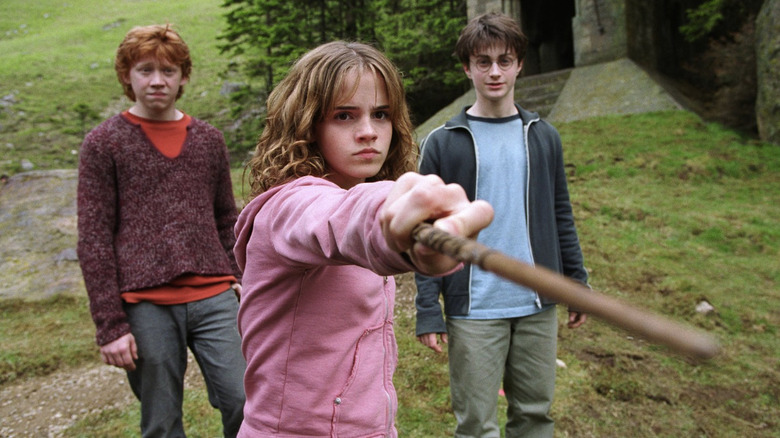 Hermione pointing her wand at someone while Ron and Harry watch in Harry Potter and the Prisoner of Azkaban