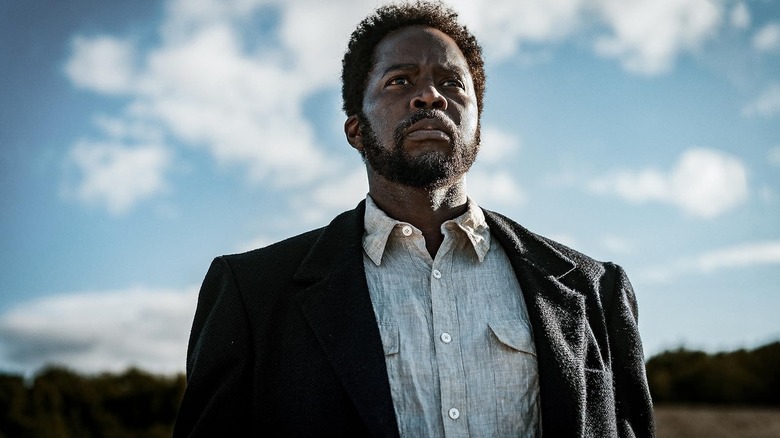 Harold Perrineau as Boyd standing in front of a cloudy sky in From