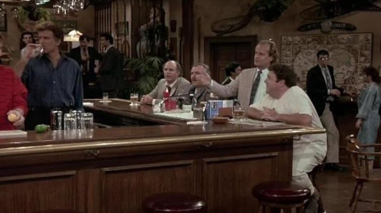 Sam is behind the bar at Cheers while Norm, Frasier, Sam, and others mill around on Cheers