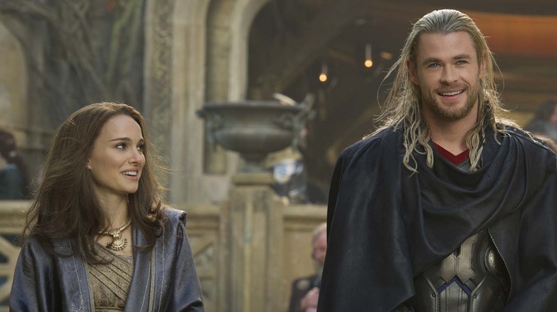 natalie portman as jane foster looking at chris hemsworth as thor who is smiling