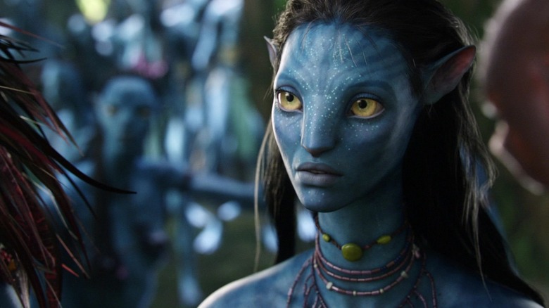 Neytiri de Zoe Saldana mira a través del marco mientras habla con otro Na'vi en Avatar